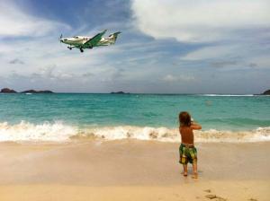 child-watching-plane-on-beach